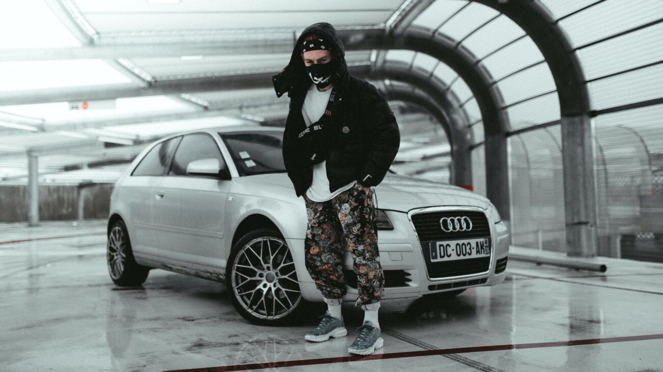 This time he is standing in front of the car.